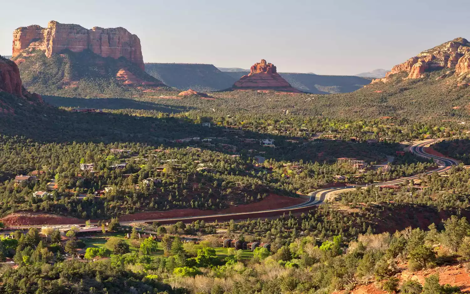 A highway curving through the iconic red rock formations of Sedona, Arizona.