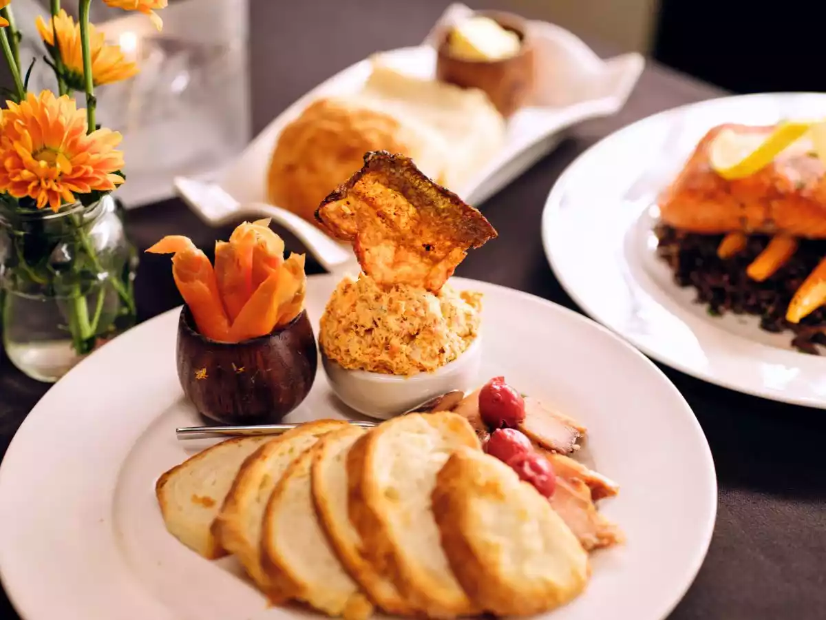 A close-up of a traditional salmon and bannock dish served on a modern plate.