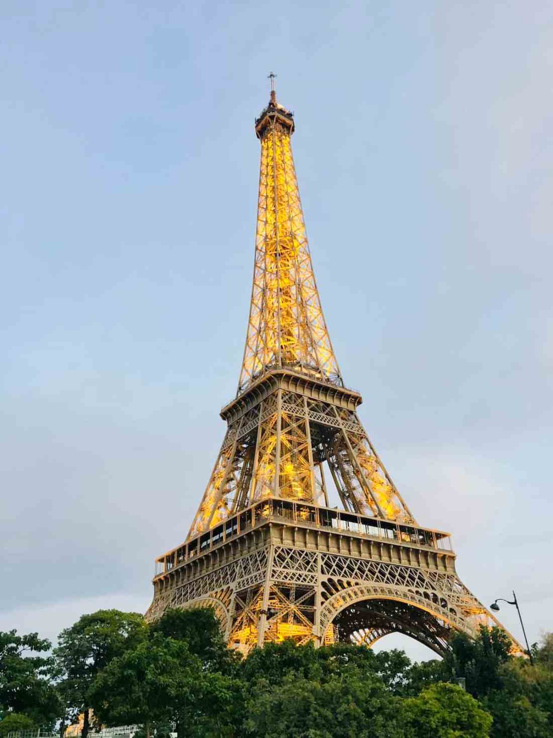 The Eiffel Tower in Paris glowing with golden lights at night.