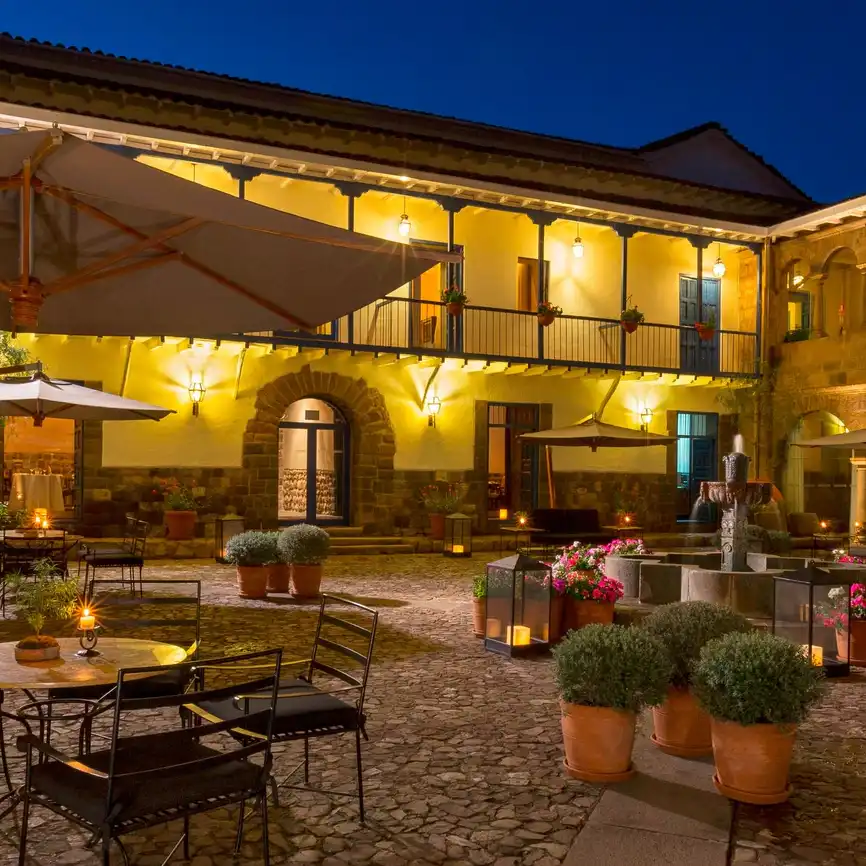 A courtyard fountain surrounded by stone arches at Palacio del Inka.