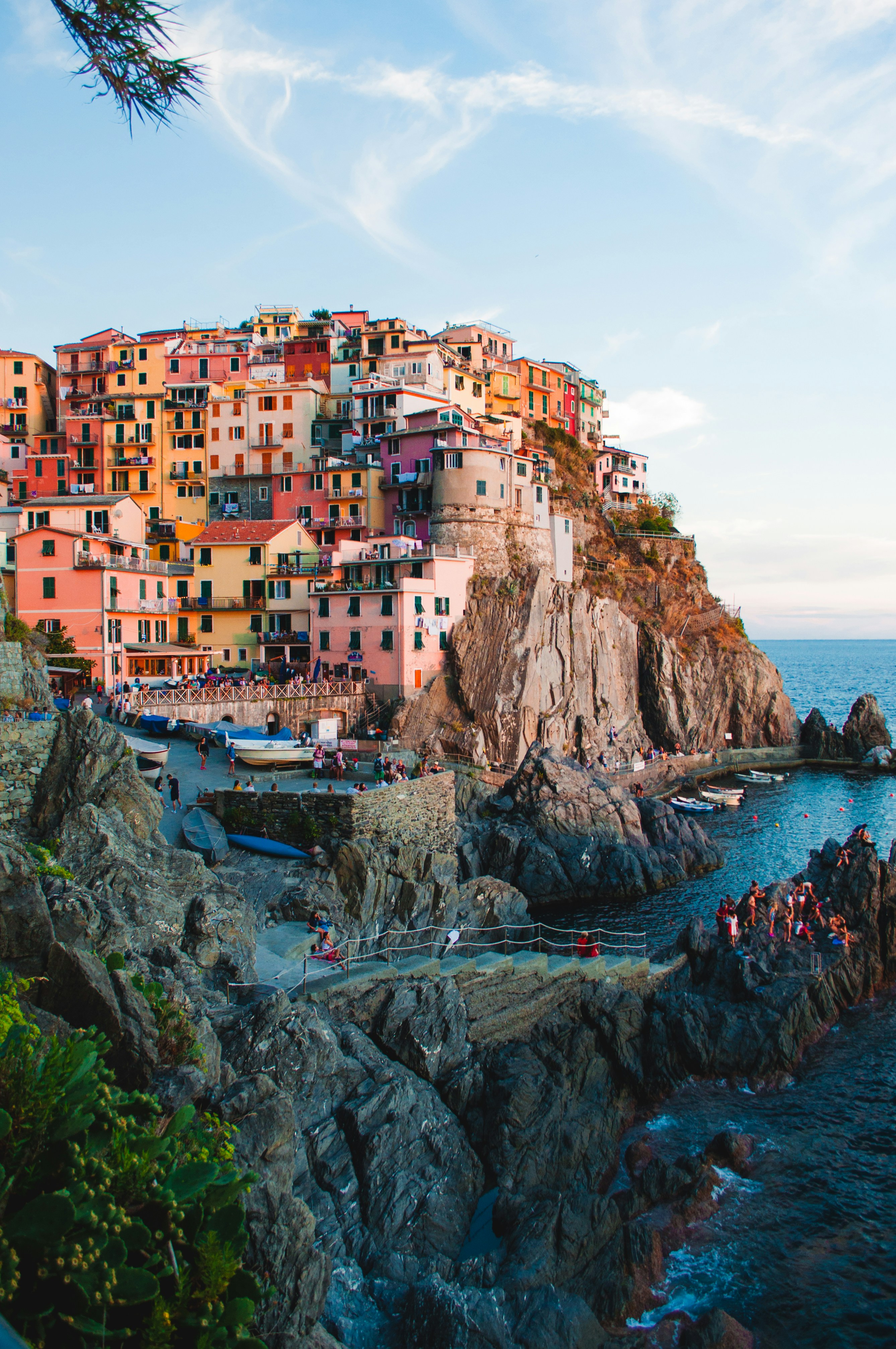 A historic marina in Porto Ercole, Tuscany, featuring old stone fortresses and moored boats.