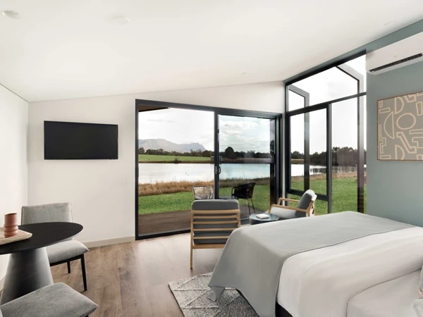 Minimalist interior of a luxury suite with wooden accents and neutral tones.