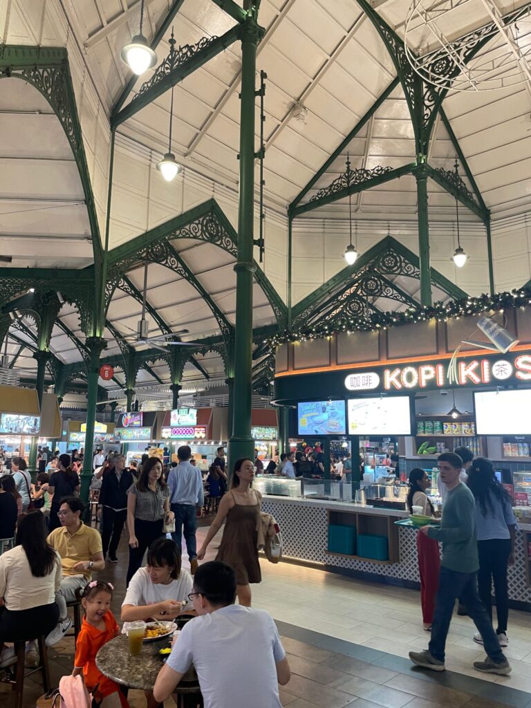 A variety of Singaporean hawker dishes, including noodles and meat, served on a traditional table.