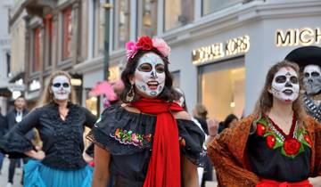 Participants in traditional face paint and costumes celebrating Day of the Dead in Mexico City.
