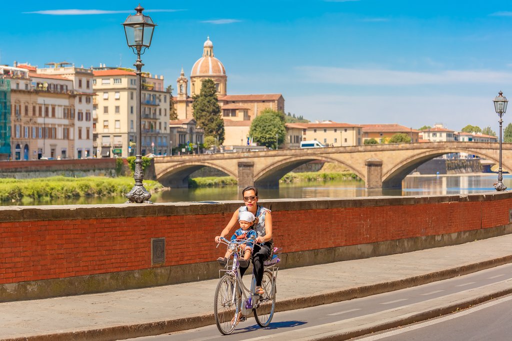 A paved bicycle path running alongside the River Arno in Florence.