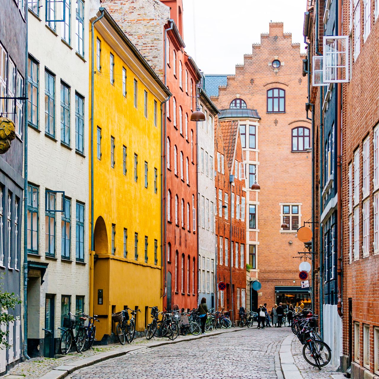 A wide street view of Copenhagen with clear cycling lanes and city buildings.