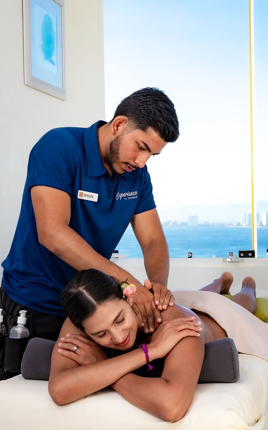 A person receiving a massage at an outdoor spa with the ocean in the background.