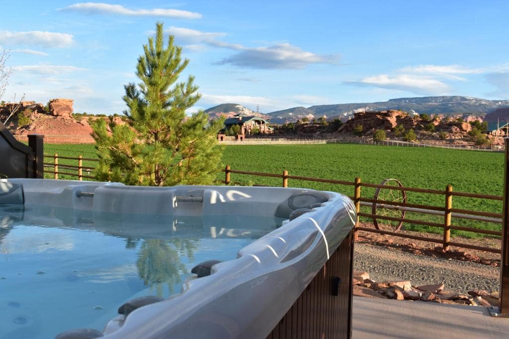 An outdoor hot tub at Cougar Ridge Lodge with a view of the desert and red rock mountains.