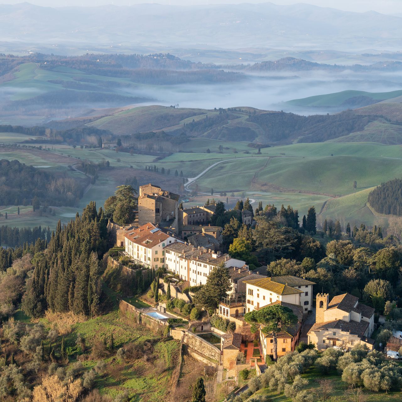 A wide panoramic view of a luxurious resort nestled in the green European countryside.
