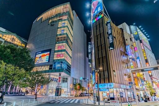 Vibrant and busy street in Shinjuku filled with neon signs and crowds.