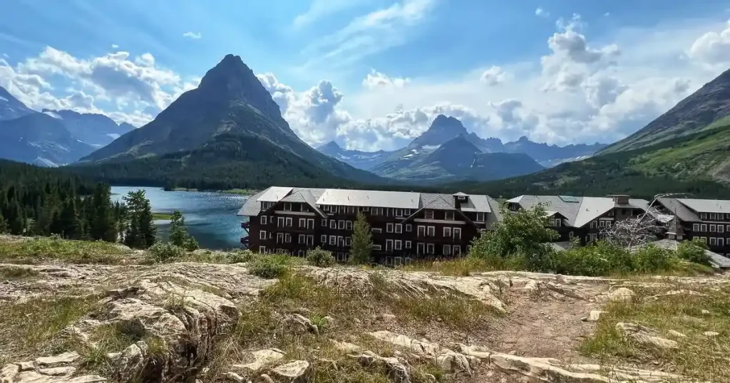 The historic Many Glacier Hotel situated on the edge of Swiftcurrent Lake with rugged mountains in the background.