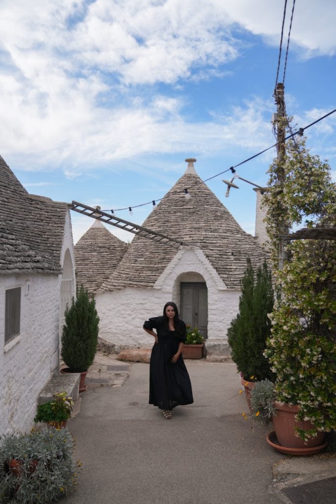 Traditional white limestone Trulli houses with grey conical roofs in the town of Alberobello.