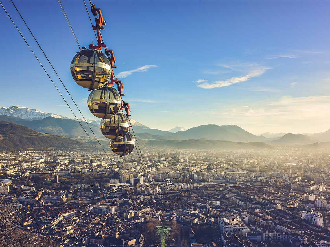 Spherical glass cable cars ascending a mountain in Grenoble.