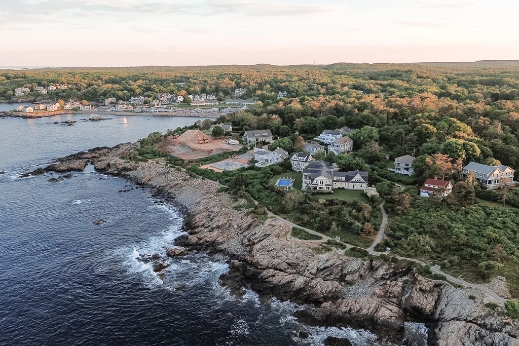 Aerial view of the Marginal Way walking path along the rocky coastline of Ogunquit at sunset.