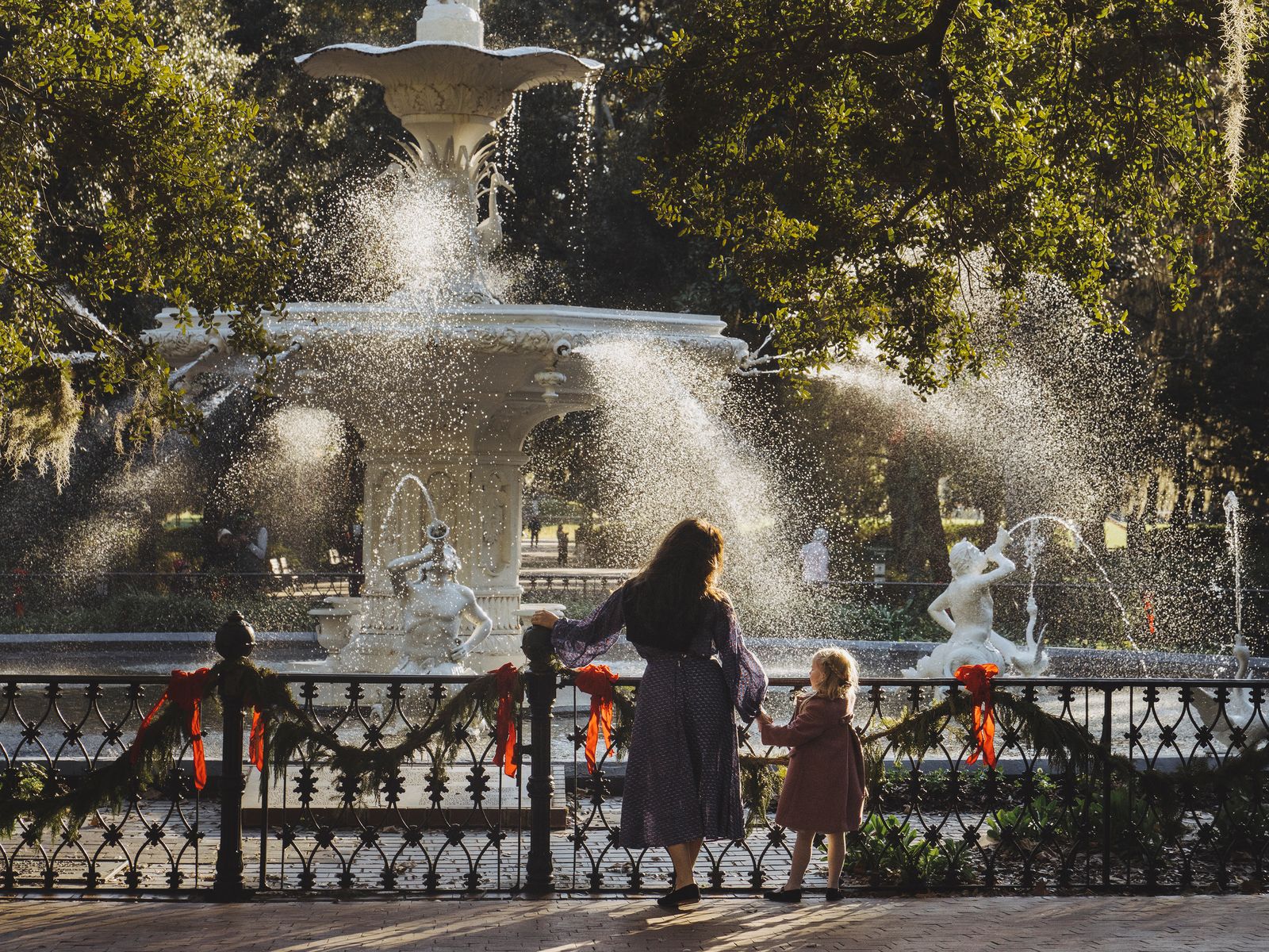 Historic Savannah streetscape with traditional brick buildings and oak trees draped in Spanish moss.