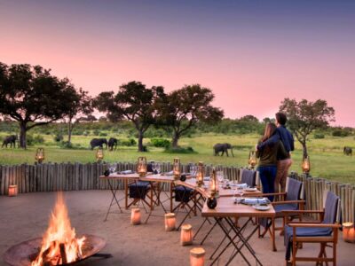 A private outdoor dinner setup for two in the middle of a remote African wilderness area.