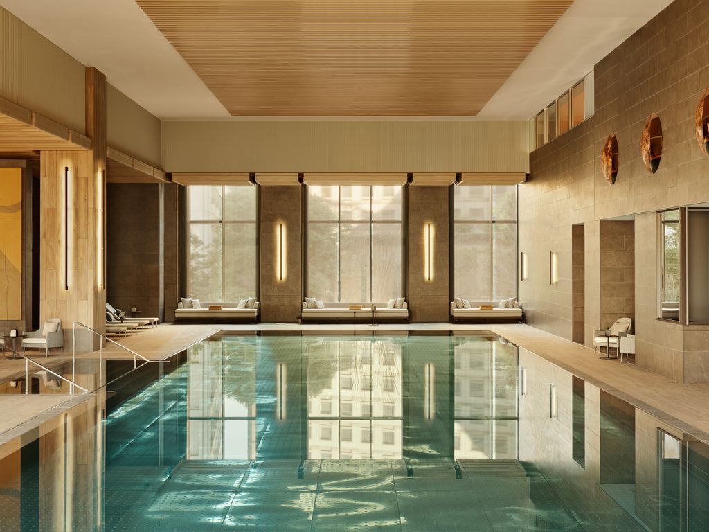 Modern indoor swimming pool at Janu Tokyo with minimalist architecture and warm lighting.