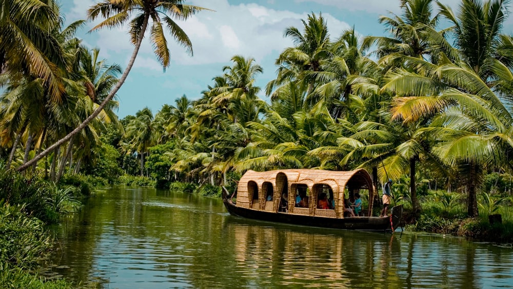 A traditional wooden houseboat floating on the calm, green waters of Kerala.