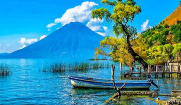 Wide landscape view showing multiple volcanic peaks rising above the clouds in Guatemala.