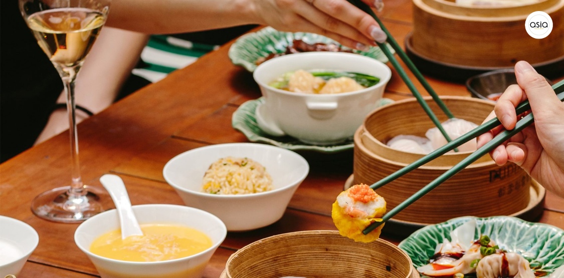 Multiple bamboo steamers filled with various types of dim sum on a restaurant table.