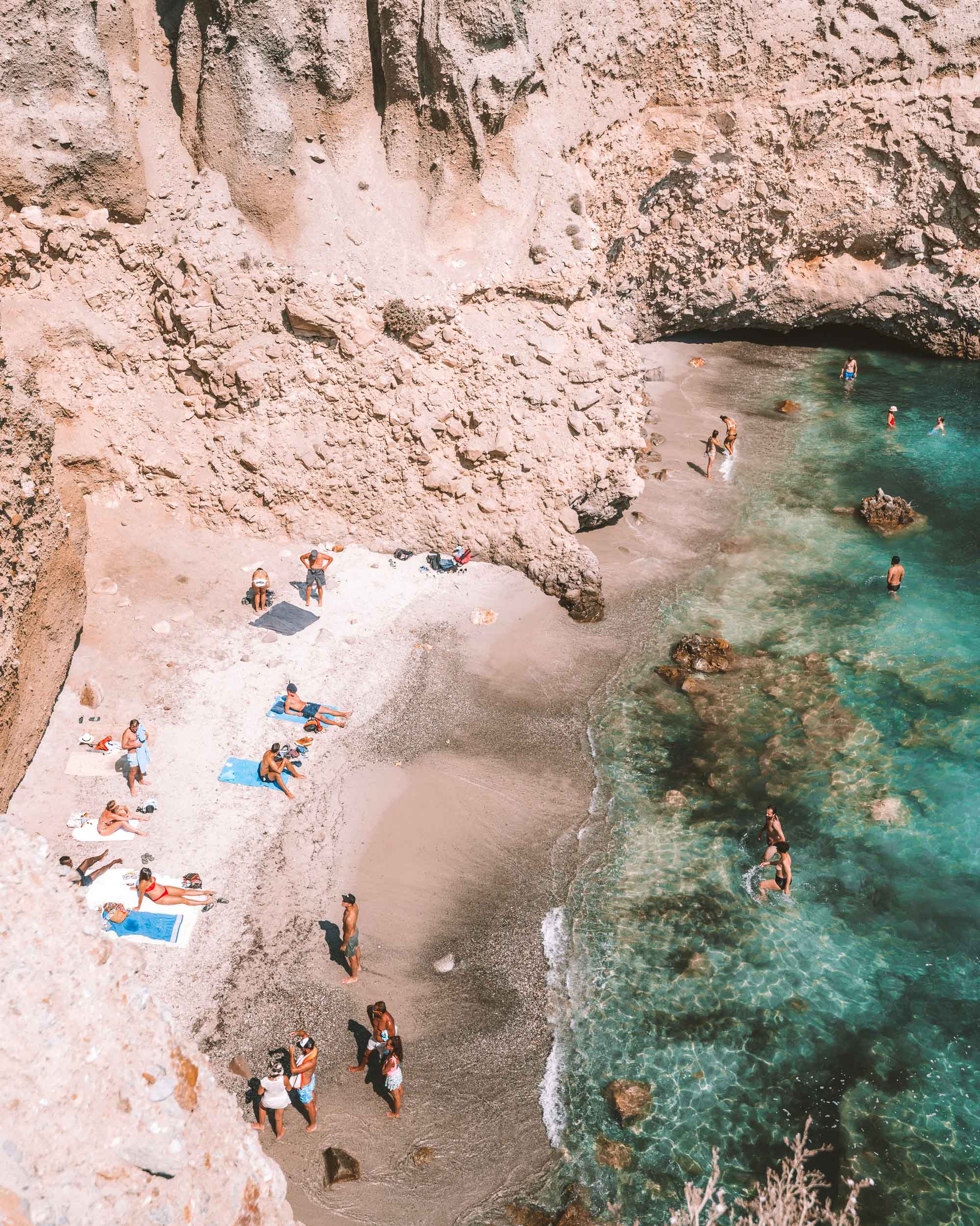 High-angle view of the small, secluded cove at Tsigrado Beach with clear turquoise water.