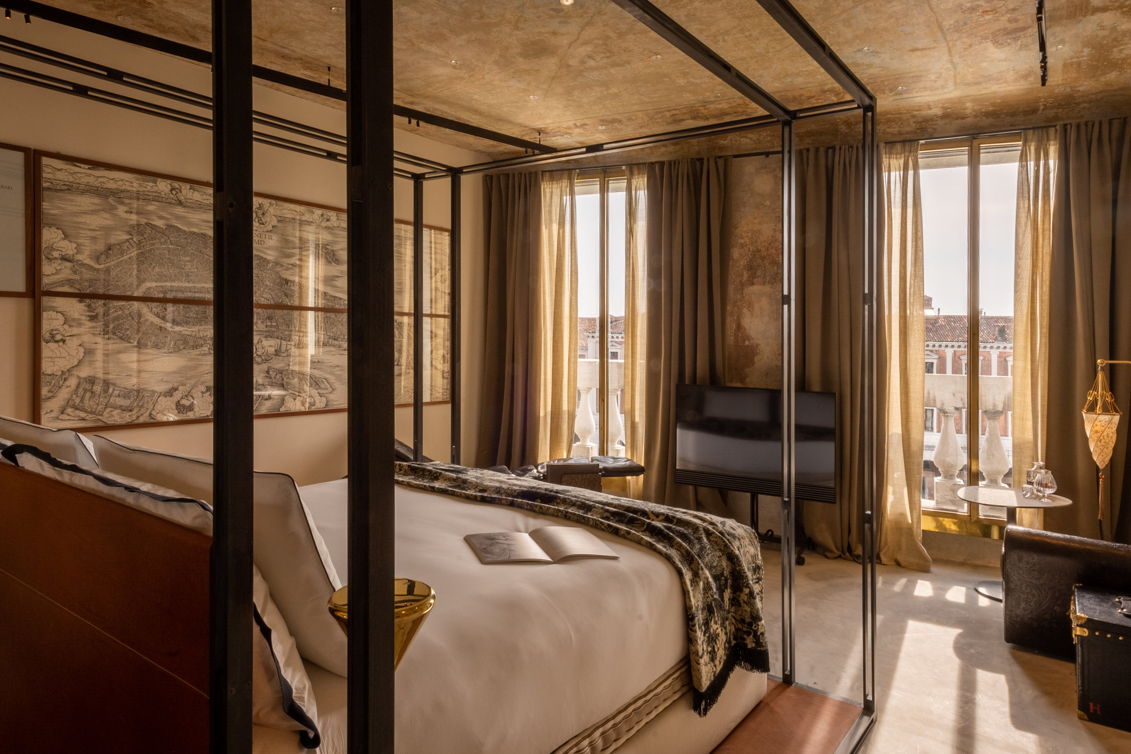 A hotel suite featuring ancient wooden ceiling beams contrasted with modern art and avant-garde furniture.