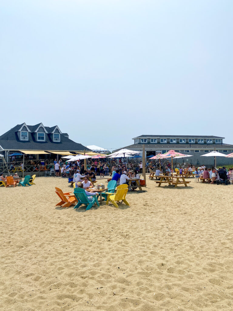 Weathered wooden stairs leading down a grassy dune toward the turquoise ocean.