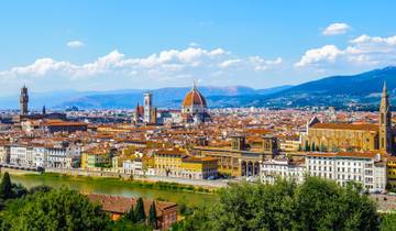 Vineyards and walking trails winding through the Tuscan wine region under a soft sky.