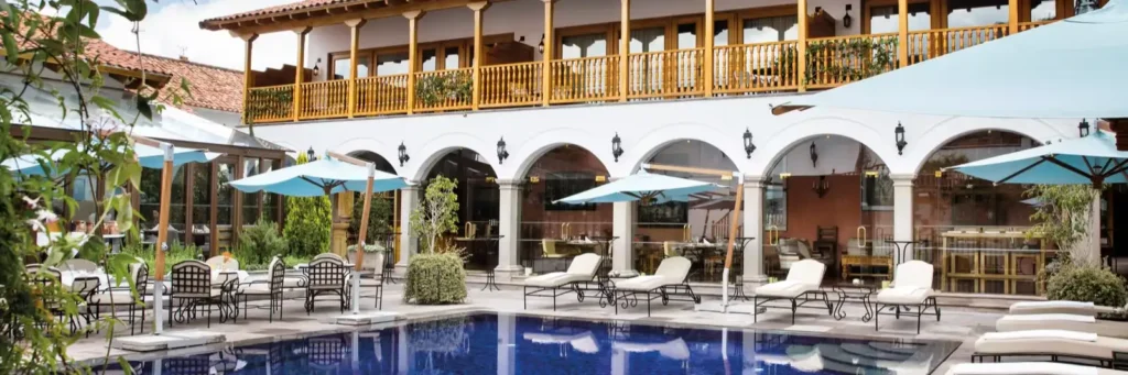 An outdoor luxury swimming pool surrounded by colonial architecture at Palacio Nazarenas.