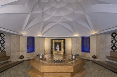 Traditional Arabian architectural details of a luxury desert resort with earthen walls and wooden beams.