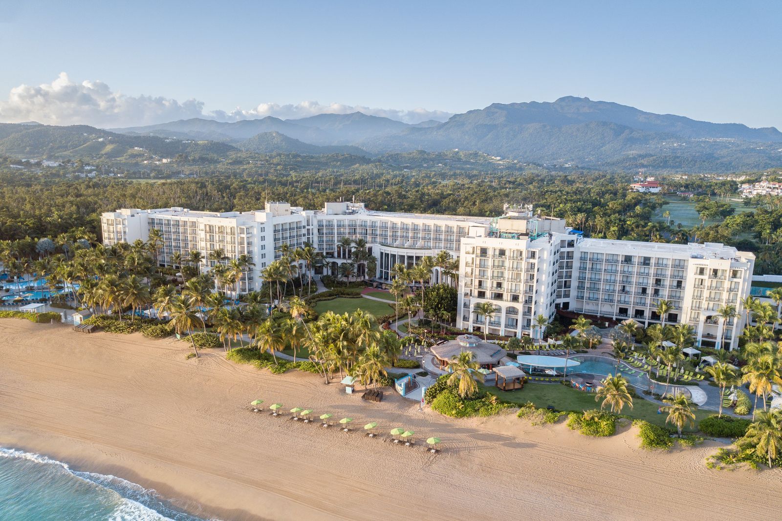 Aerial view of a large beachfront resort in Puerto Rico with multiple pools and ocean access.