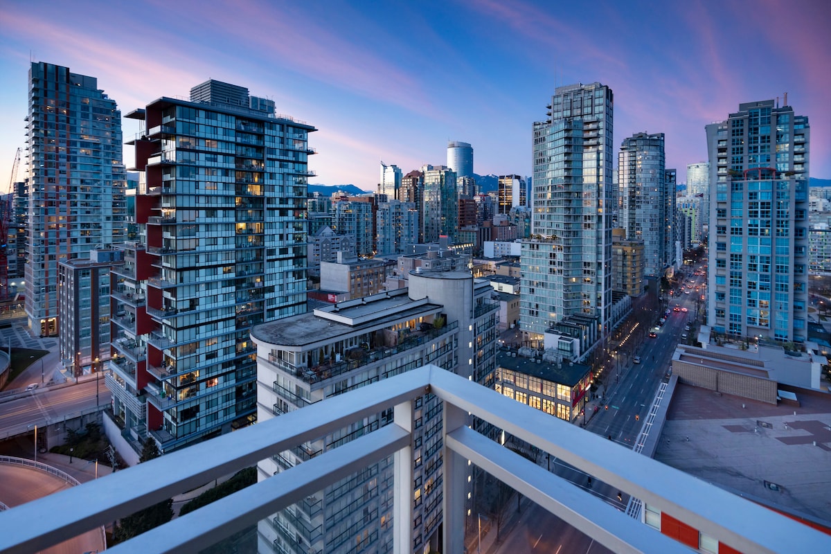 The twilight skyline of Vancouver skyscrapers reflecting in the water.