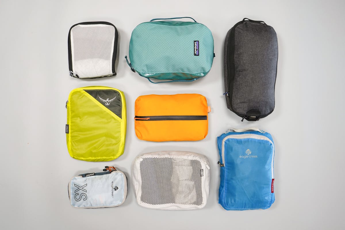 Several different sized packing cubes used for organizing clothing inside a suitcase or backpack.