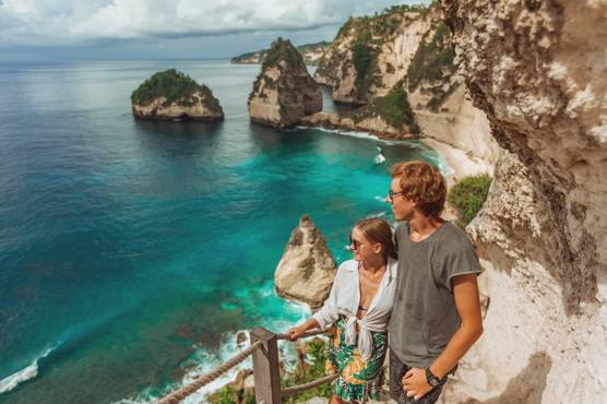 A skilled surfer riding a powerful turquoise wave in Bali.