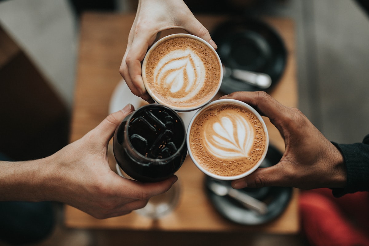 A barista preparing a cup of coffee in a modern cafe environment.
