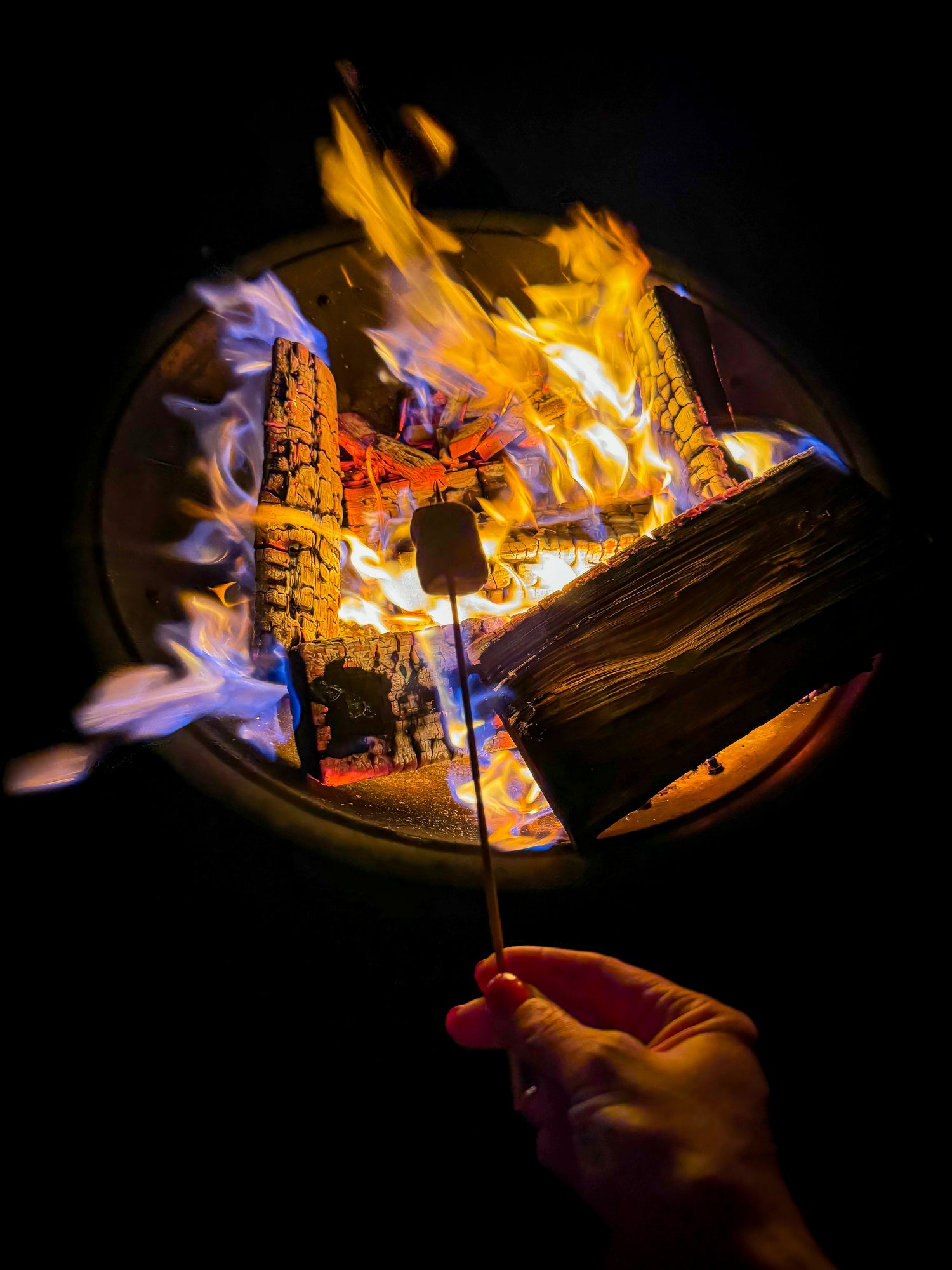 A group of people practicing yoga on an outdoor wooden deck overlooking the countryside.