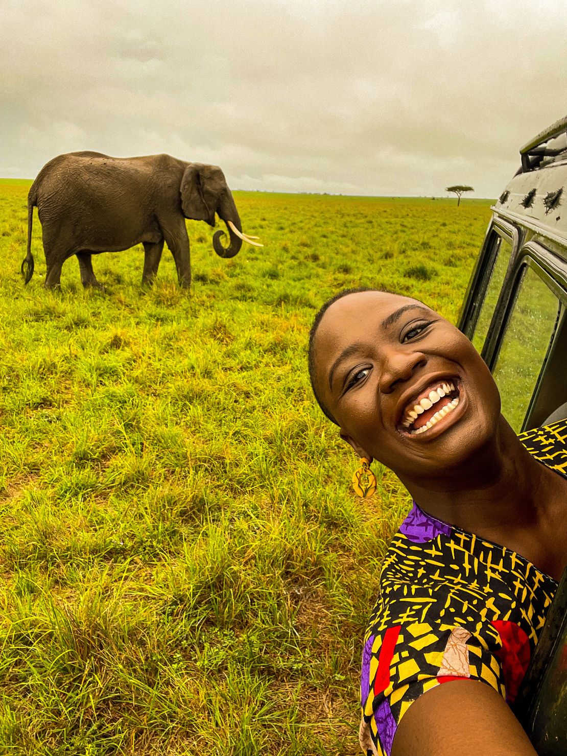 Pelumi Nubi standing in a scenic outdoor setting in Kenya during a previous trip.
