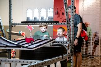 Children engaging with physical engineering and sports-themed exhibits.