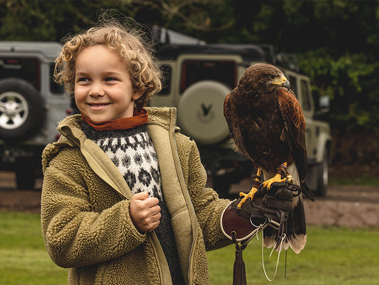 A falconry experience taking place in the green hills of the Scottish estate.