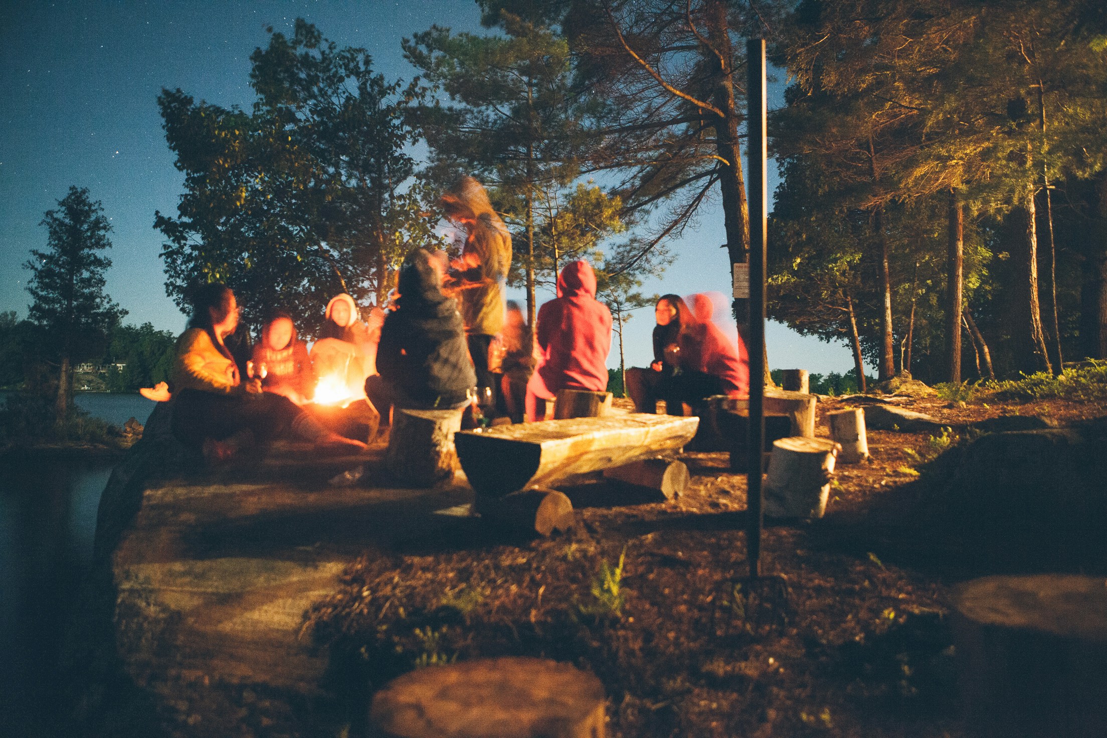 A small, controlled campfire at a designated park campground under a twilight sky.
