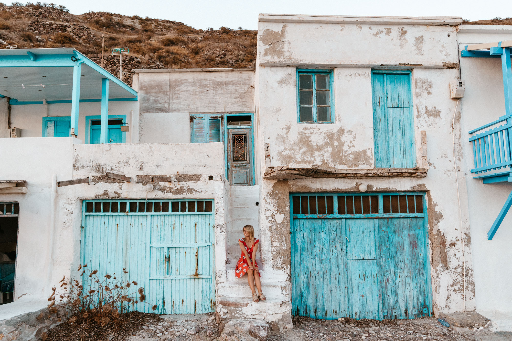Traditional colorful boathouses or syrmata at the water's edge in Klima village during sunset.