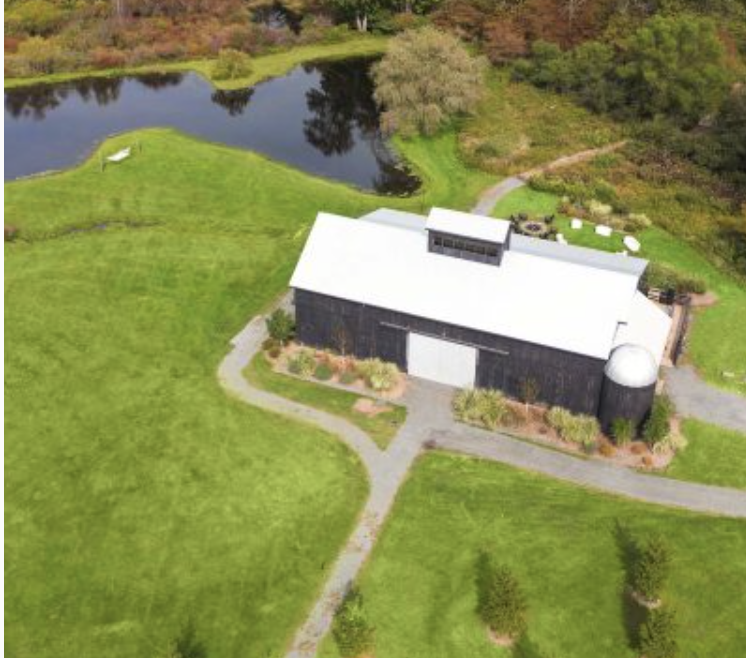A sunlit dining room with long wooden tables set for a communal group meal.