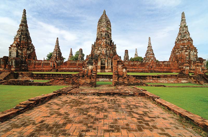 Stone Buddha statues and crumbling brick ruins at the Ayutthaya Historical Park.