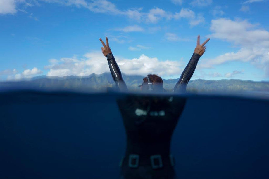 A person floating peacefully on the water's surface, looking upward.