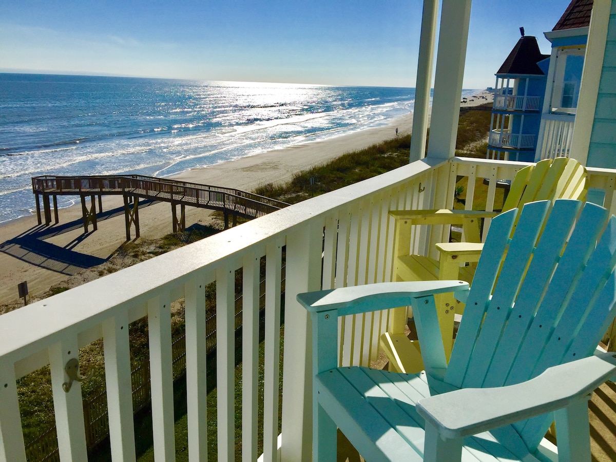 Wooden boardwalk leading from a beachfront property directly to the sandy shore.