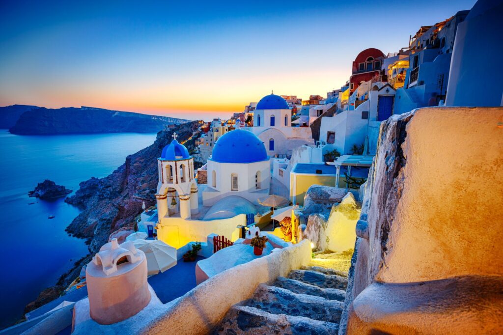 The iconic white architecture of Oia village in Santorini at dusk.