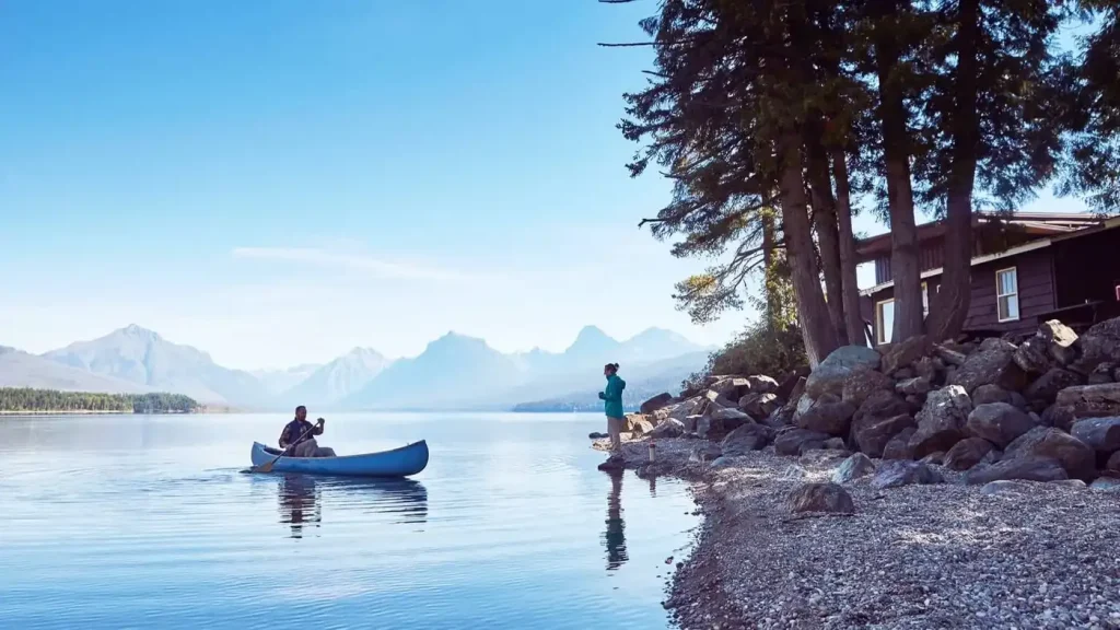A red canoe resting on the shore near the Apgar Village Lodge and Cabins at Glacier National Park.