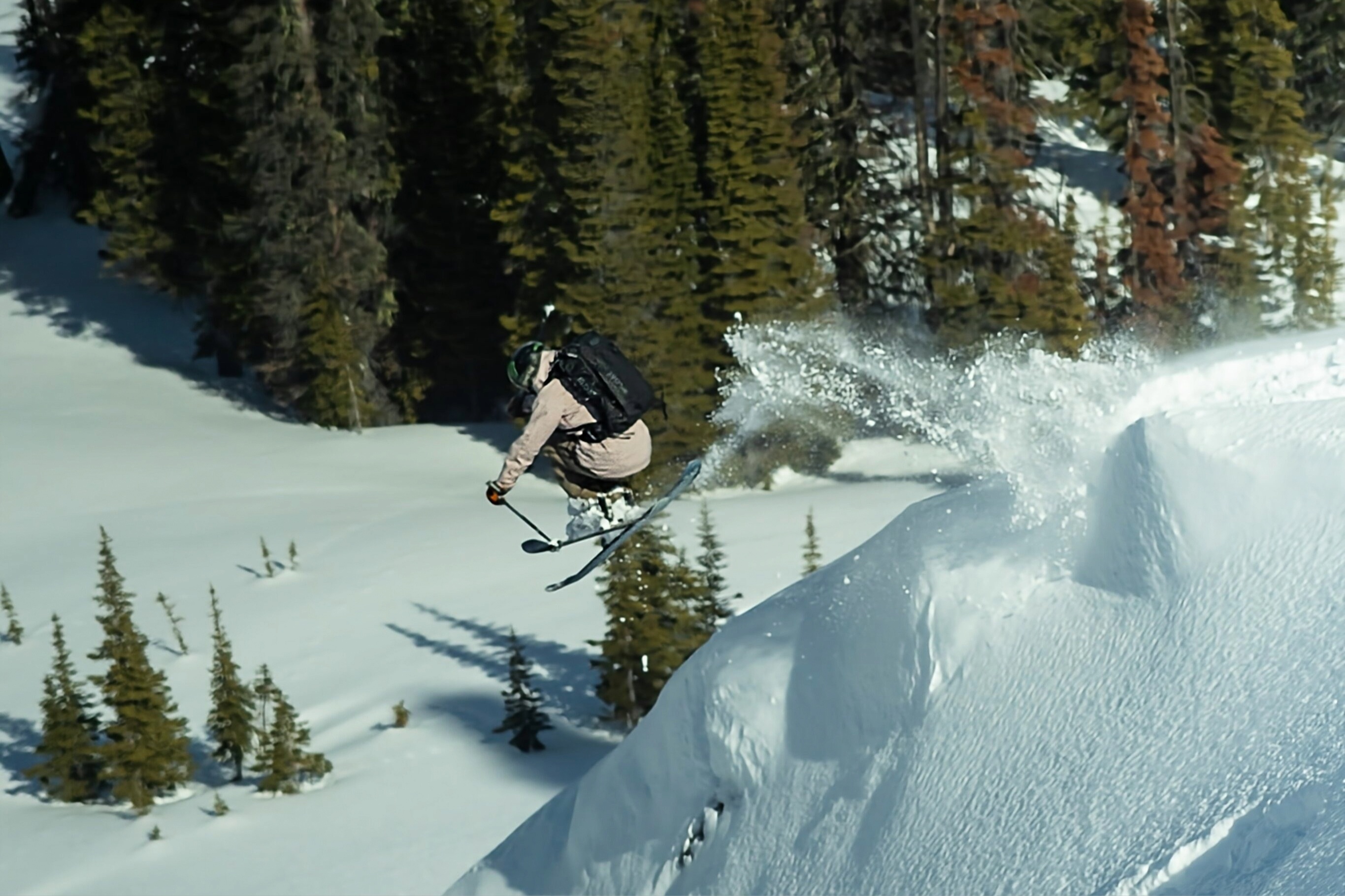 Top-down flat lay of ski goggles, gloves, a radio, and other essential backcountry accessories.