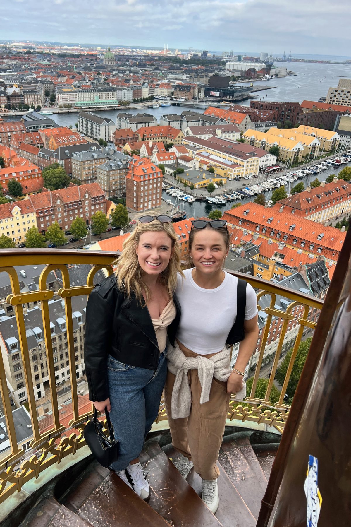 An aerial panoramic view looking down over the colorful rooftops and spires of Copenhagen.