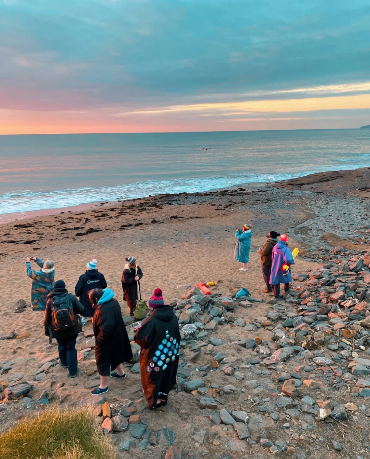 Swimmers enjoying a bright turquoise tidal pool built into the coastal rocks.